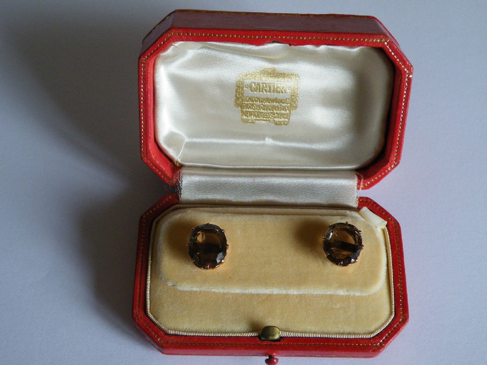 a lovely pair of smokey topaz and gold stud earrings in a cartier box