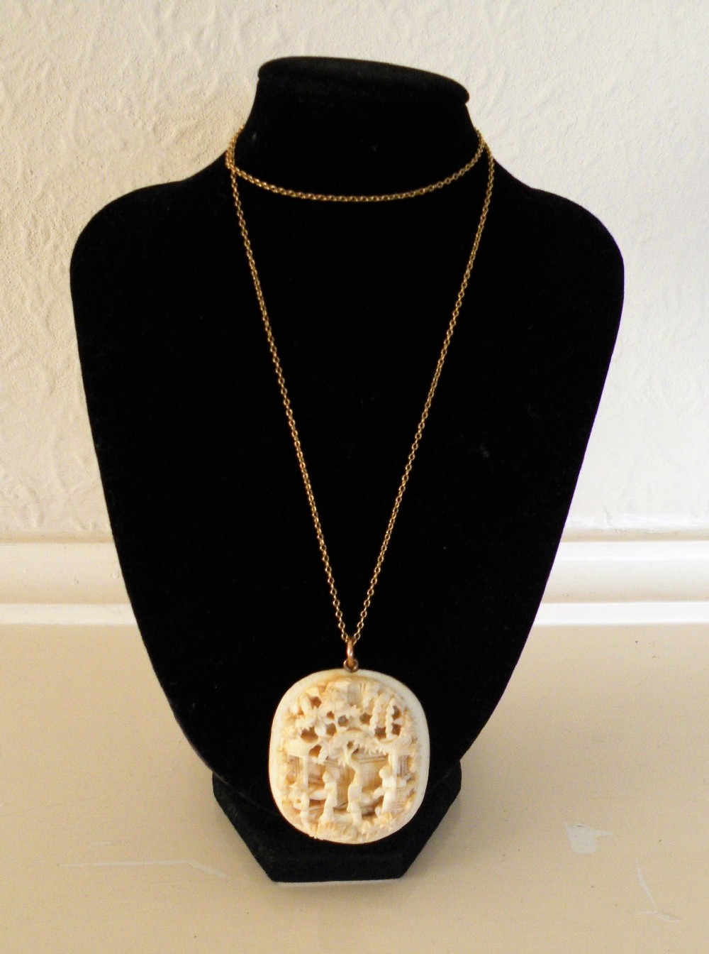 a 19th century carved ivory pendant on a gold chain