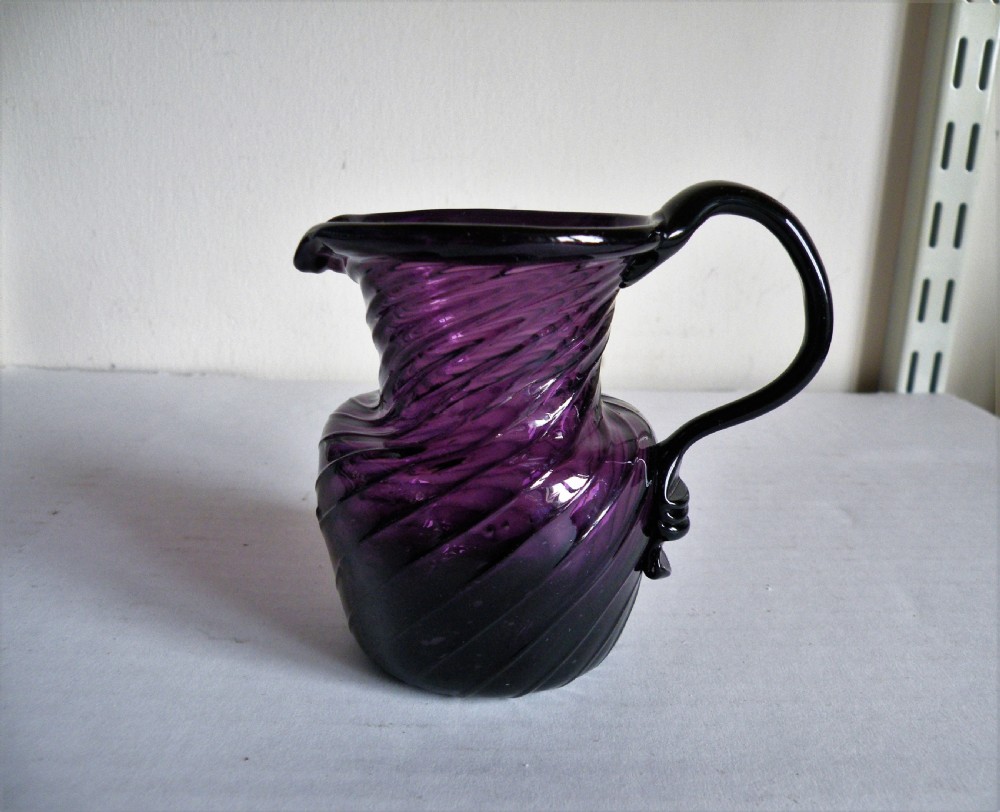 an 18th century amethyst glass cream jug