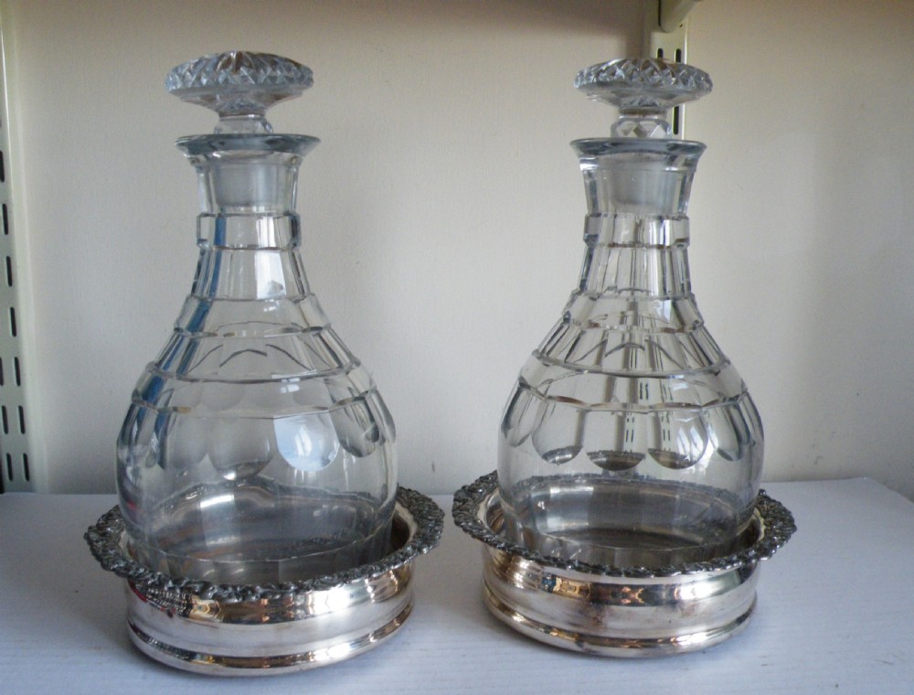 a good heavy pair of georgian cut glass decanters and silver plate coasters